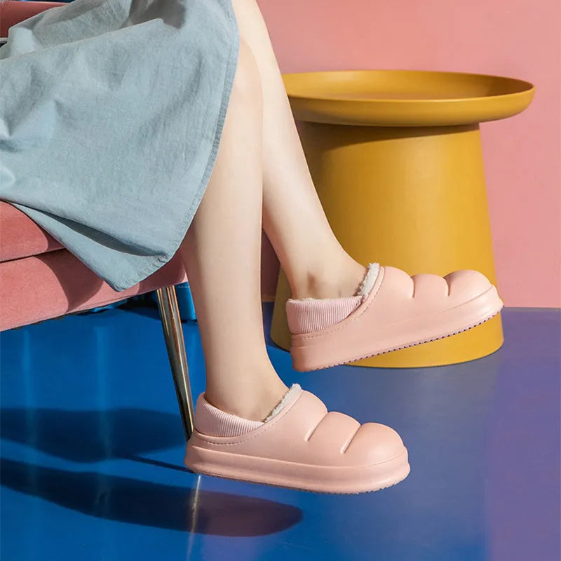 A pair of waterproof EVA couple slippers with a warm plush lining, shown in a green colour option.