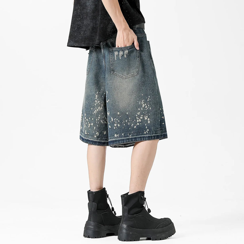 Retro blue washed denim shorts for men with ripped splash ink details and a straight leg cut.