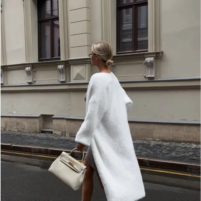 White thick knitted women's cardigan jacket with long sleeves and extended length.