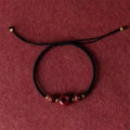 Cinnabar heart-shaped safety buckle bracelet with adjustable knot closure on wrist