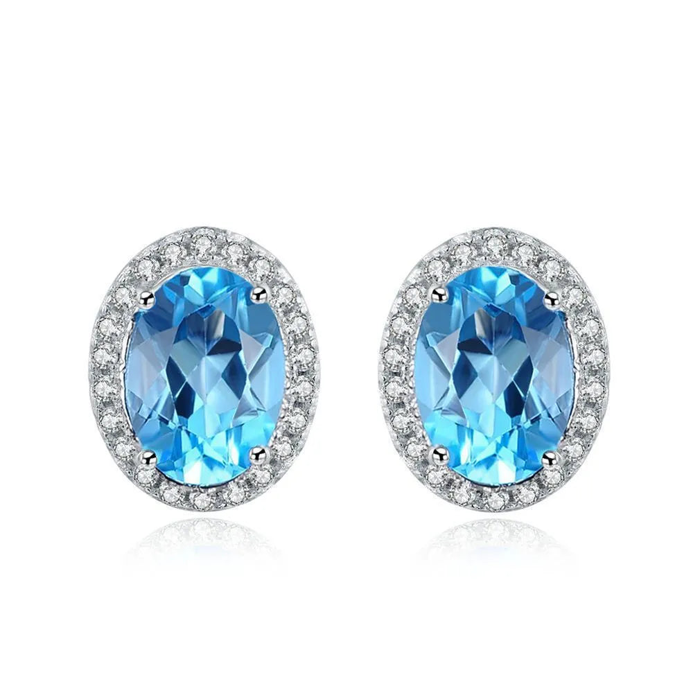 925 sterling silver geometric jewellery set with blue topaz gemstones, showing earrings, ring, pendant, and necklace.