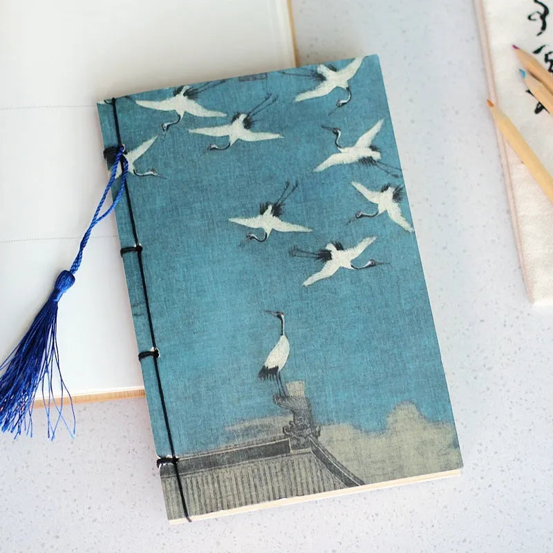 A5 antique wire-bound notebook with glossy embossed cover featuring a retro painting design, shown open.