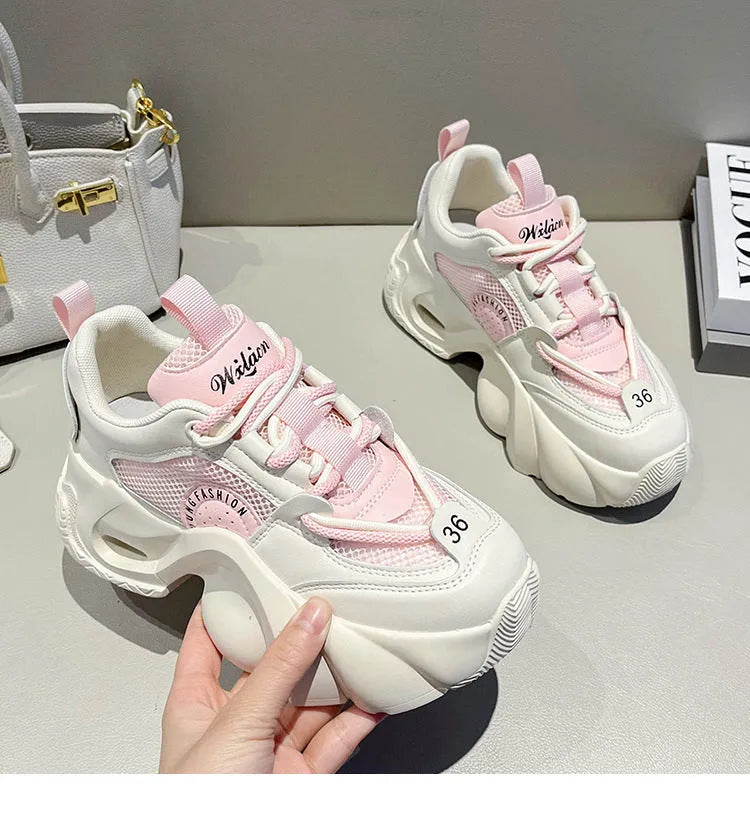 Women's pink casual sneakers with a cross strap, thick sole, and mesh lining on a white background.