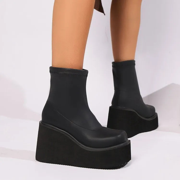 Women's black wedge boot with round toe and high cylinder, showing waterproof platform sole.