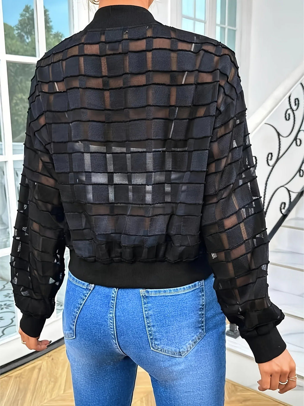 Black women's casual jacket with geometric pattern, semi-transparent fabric, long sleeves, and a front zipper.