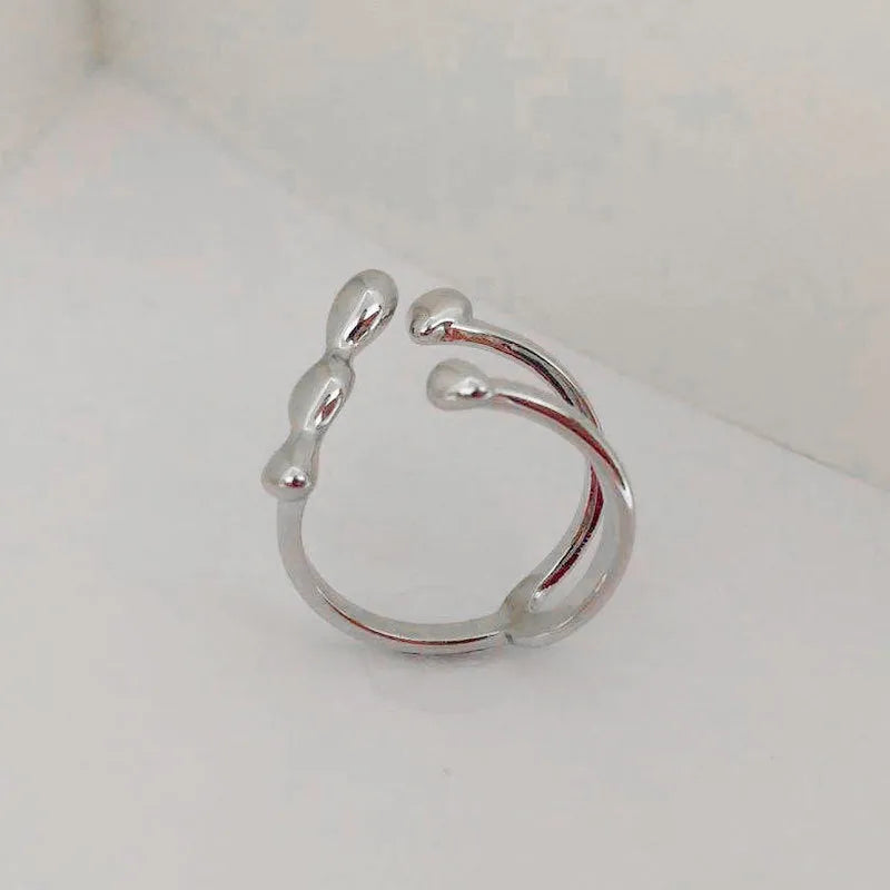 Women's brass open ring with spherical elements in gold finish showing adjustable band design