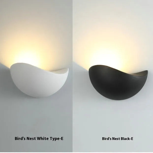 Black bird's nest design LED courtyard lamp with IP65 waterproof rating on a garden wall.