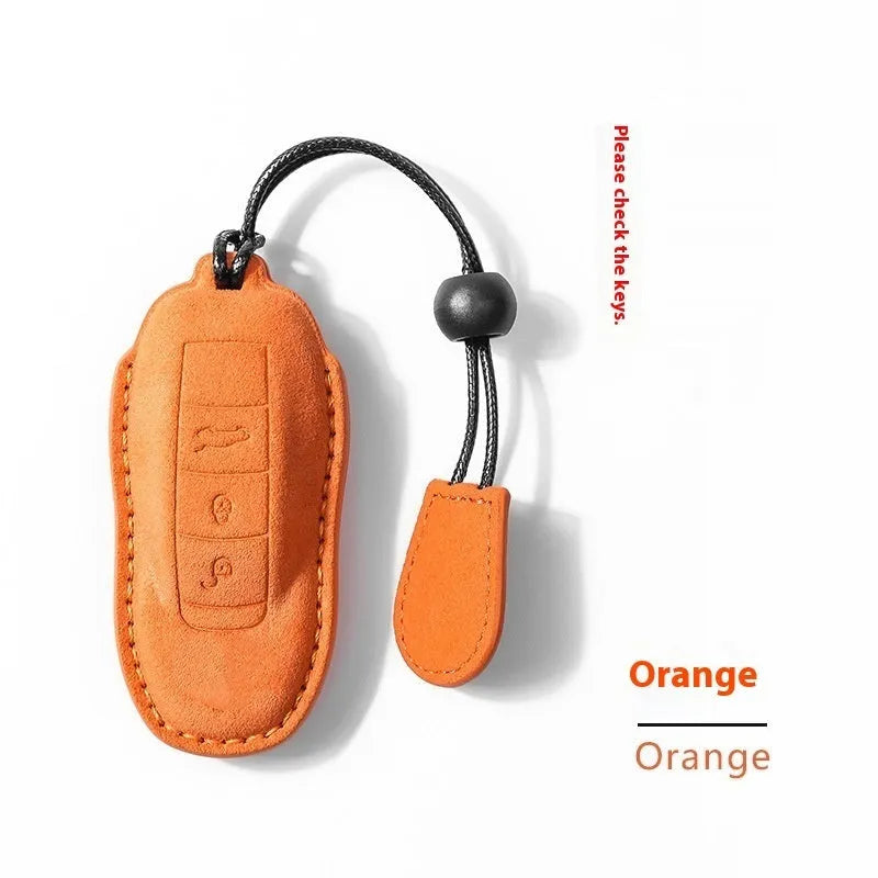 Suede car key cover in cement grey, dark green, light grey, and orange colour options