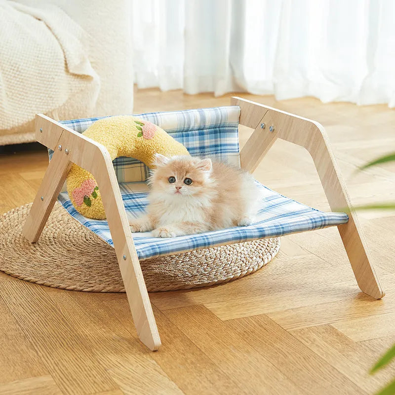 Wooden elevated cat bed with blue cloth hammock for indoor feline lounging