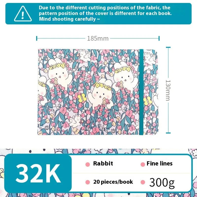 Feiluniao fabric-covered watercolour notebook open on a table with art supplies.