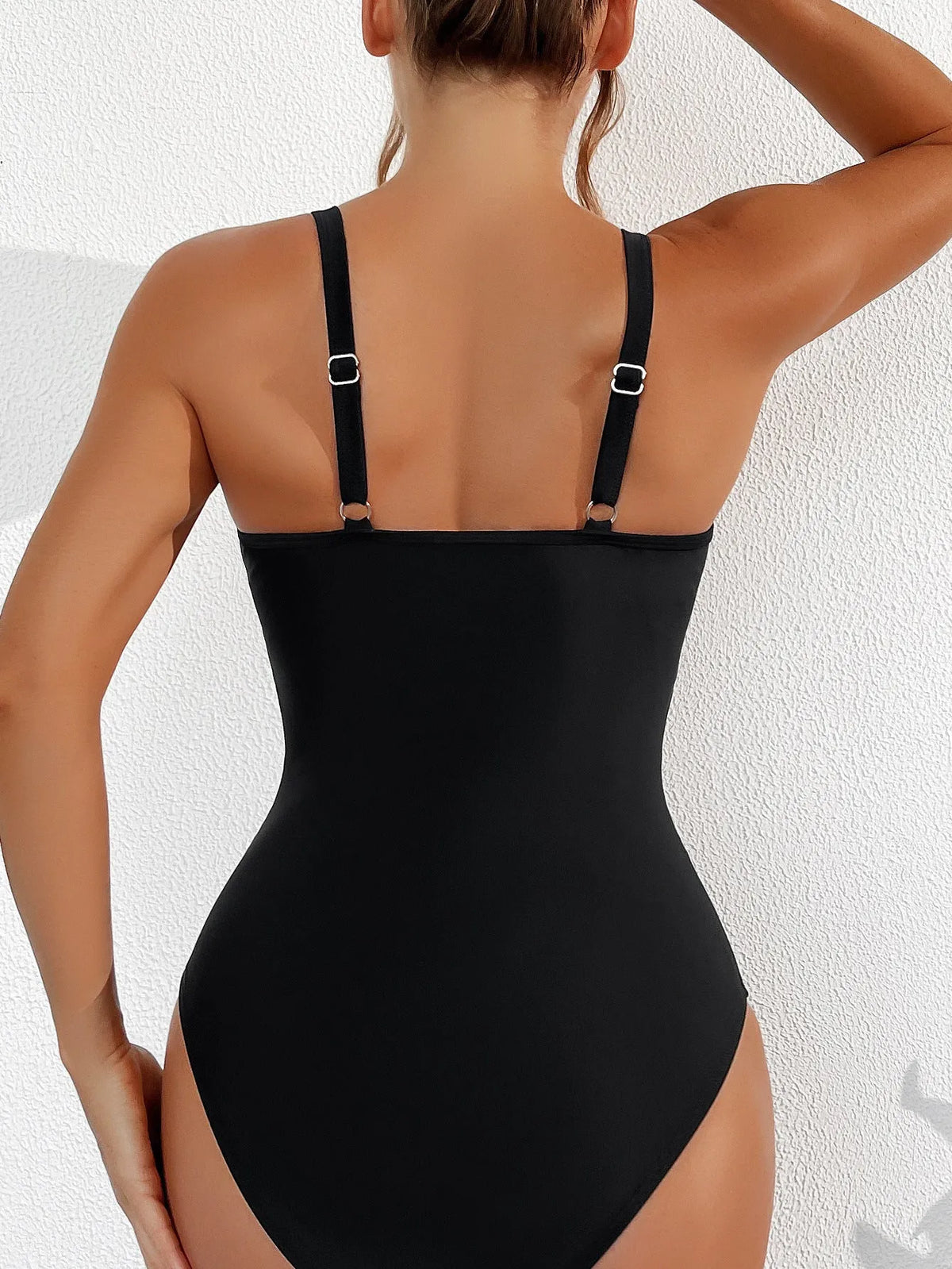 Black women's halter neck one-piece swimsuit with mesh panels and briefs style bottom.
