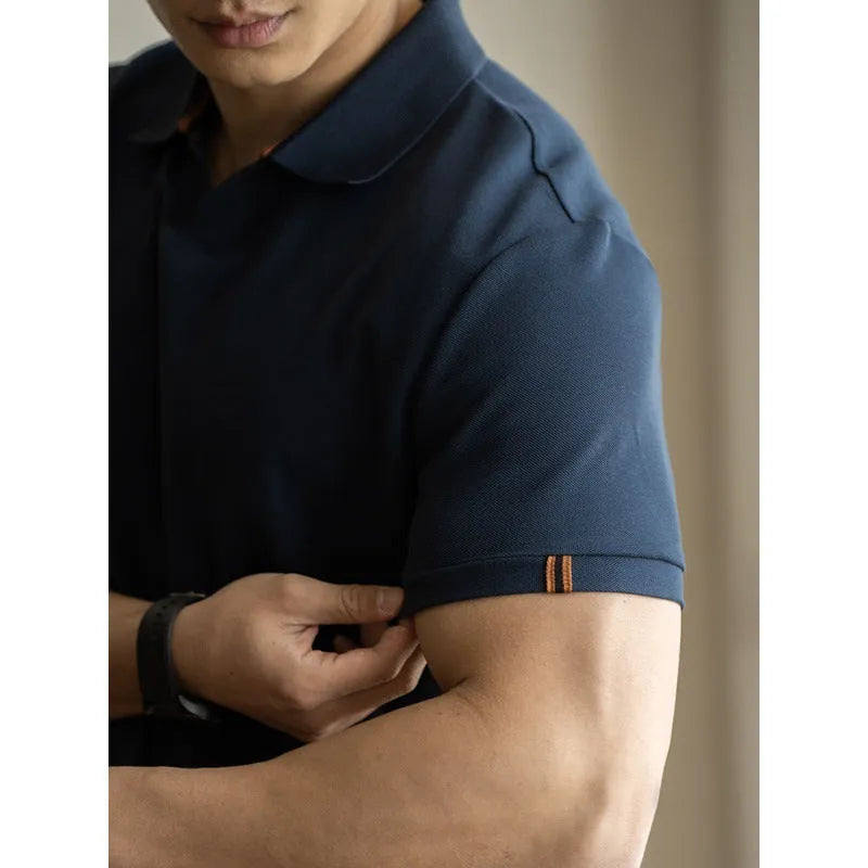 Man wearing a classic blue short-sleeved cotton blend polo shirt, showing regular fit and button placket.