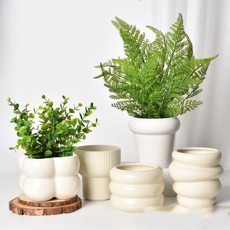 Roman column matte yellow ceramic flower pot on a surface.