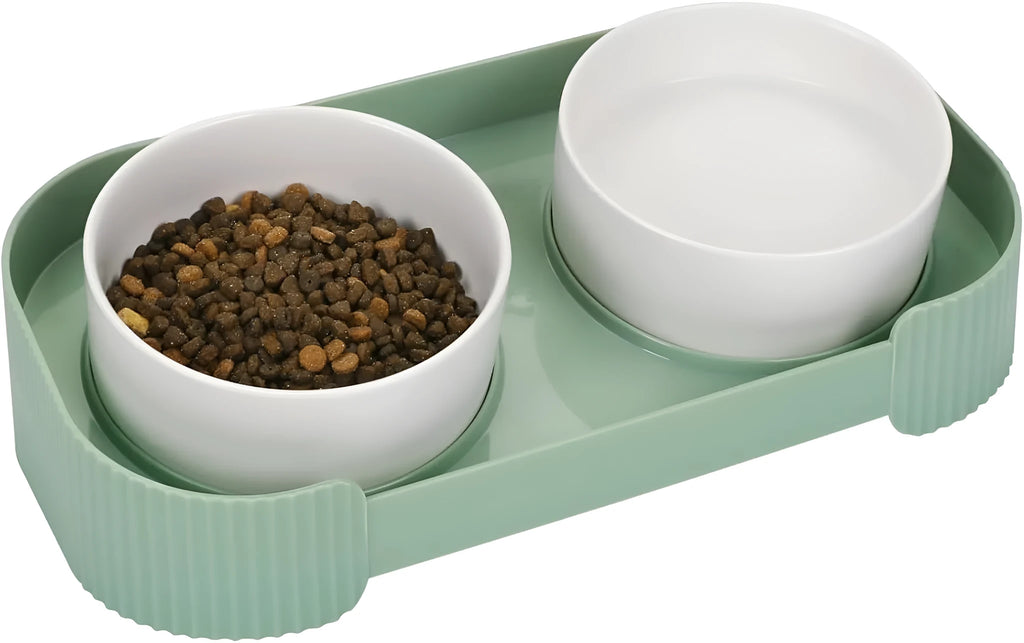 Green ceramic raised cat bowl set with two tilted bowls on a non-slip stand for food and water.