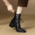 Women's black pointed toe short tube boots with 5.5cm heel on wooden floor