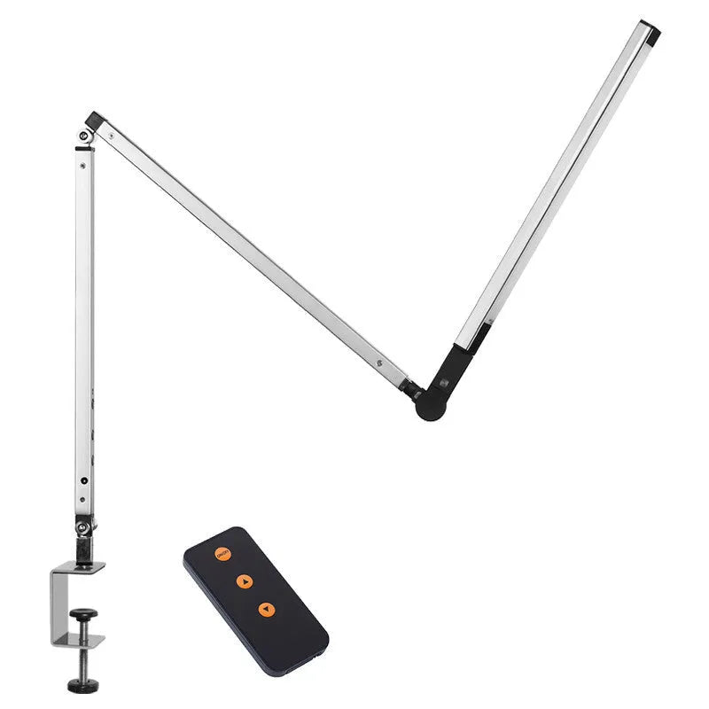 Black folding clip-on LED desk lamp with remote control on a wooden desk.