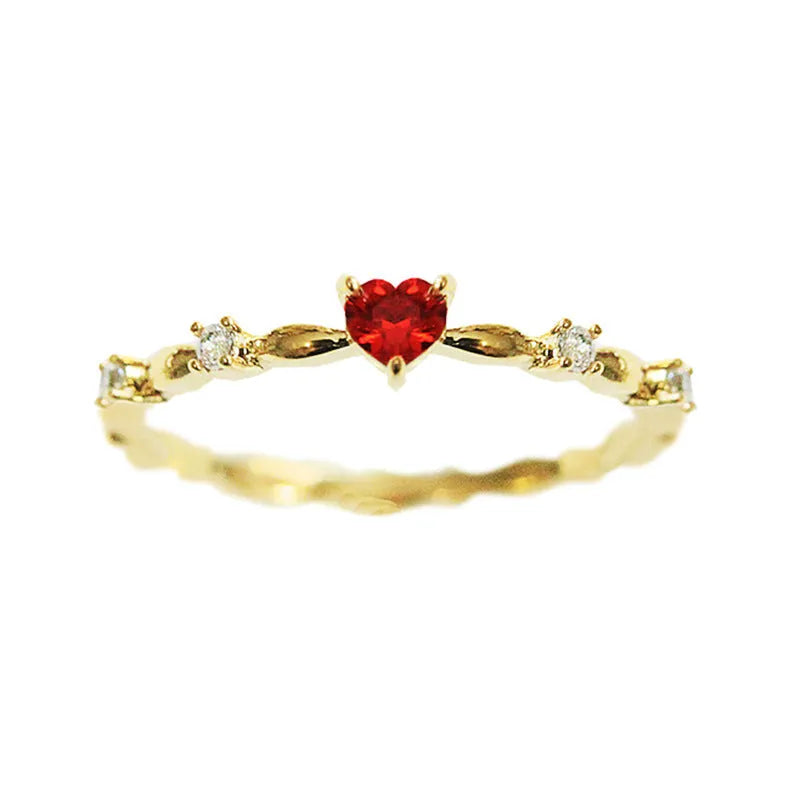 Gold or silver tone peach heart fashion ring with a zircon stone on a model finger.