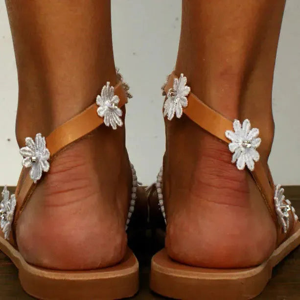 Brown women's casual sandals with flat rubber soles and floral decorations on the upper.