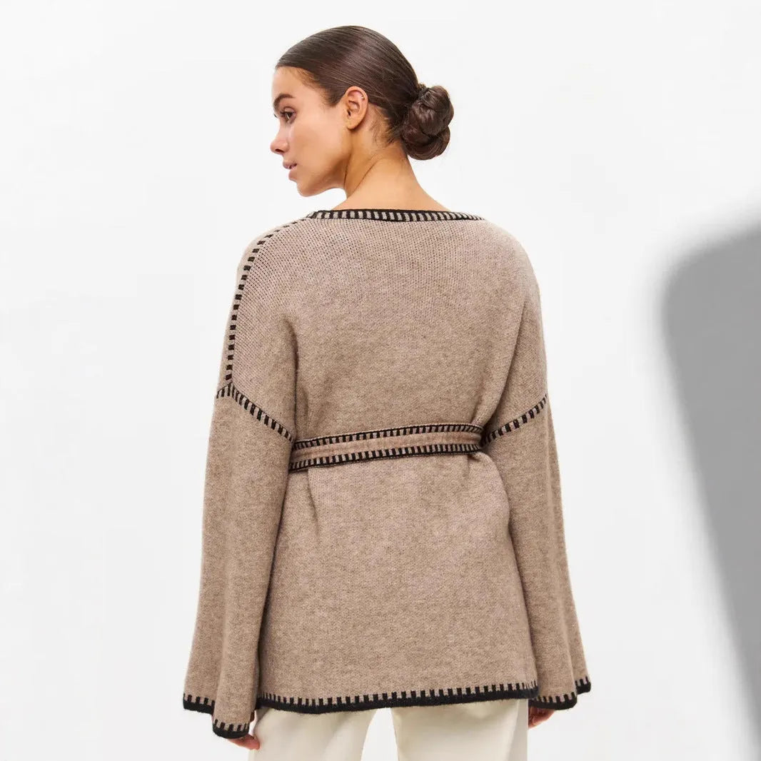 Loose mid-length knitted cardigan sweater coat with a lace-up front, shown in a neutral colour.