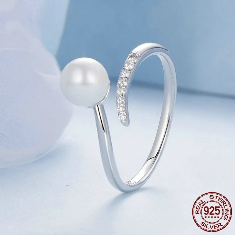 Silver adjustable ring with natural pearl centrepiece showing open loop design