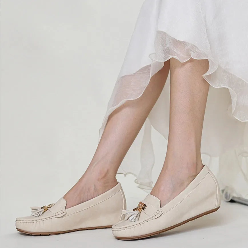 Beige oversleeve heel height increasing shoes with round toe on a white background.