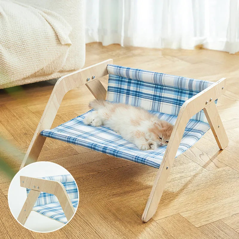 Wooden elevated cat bed with blue cloth hammock for indoor feline lounging
