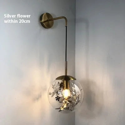 Modern glass wall lamp with metallic finish mounted beside bed for bedside lighting
