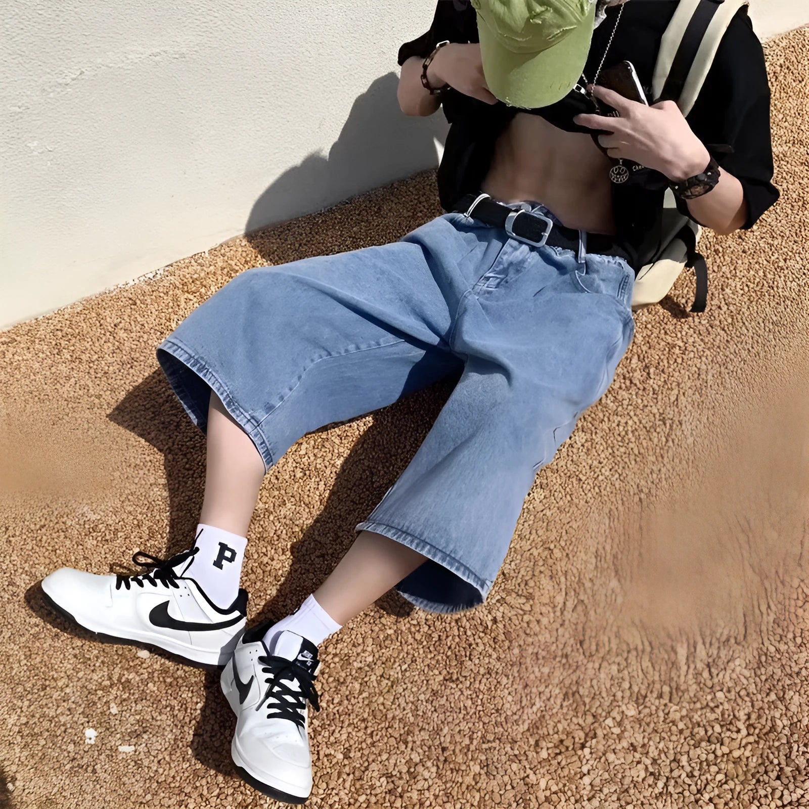 Man's washed light blue denim shorts with a high waist, cropped length, and straight legs.