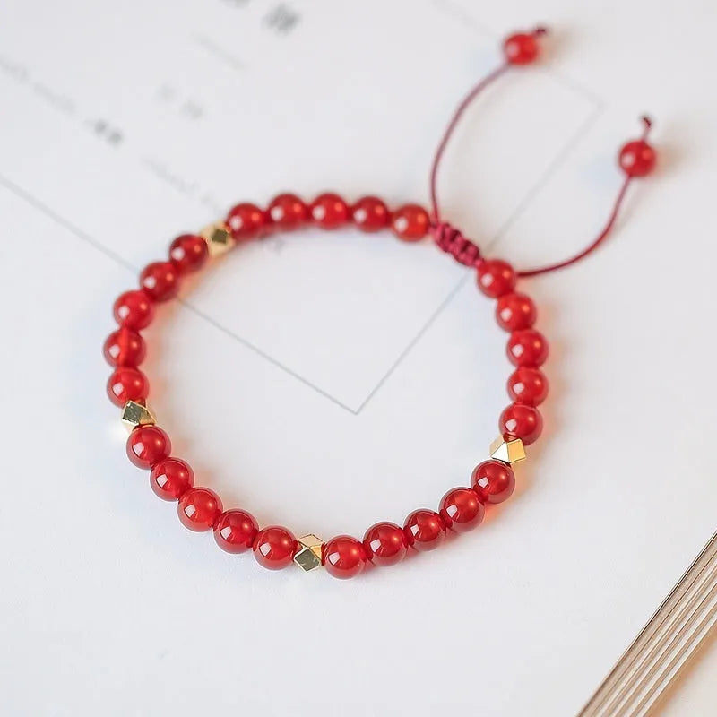 Hand-woven ethnic bracelet with natural red agate beads in diamond shapes showing woven pattern detail