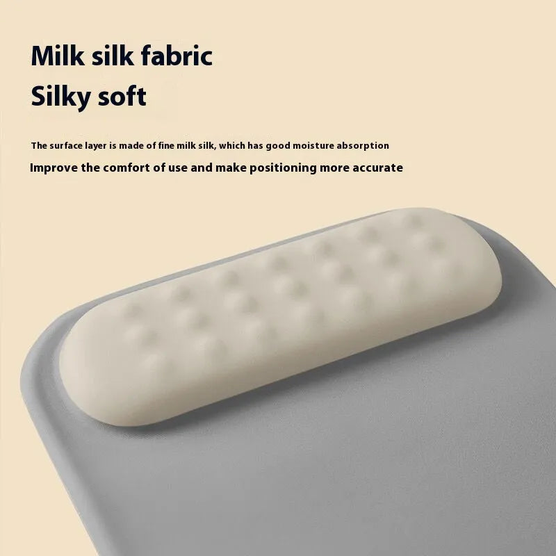 Ergonomic cloth-silicone mouse pad with raised wrist support on a desk