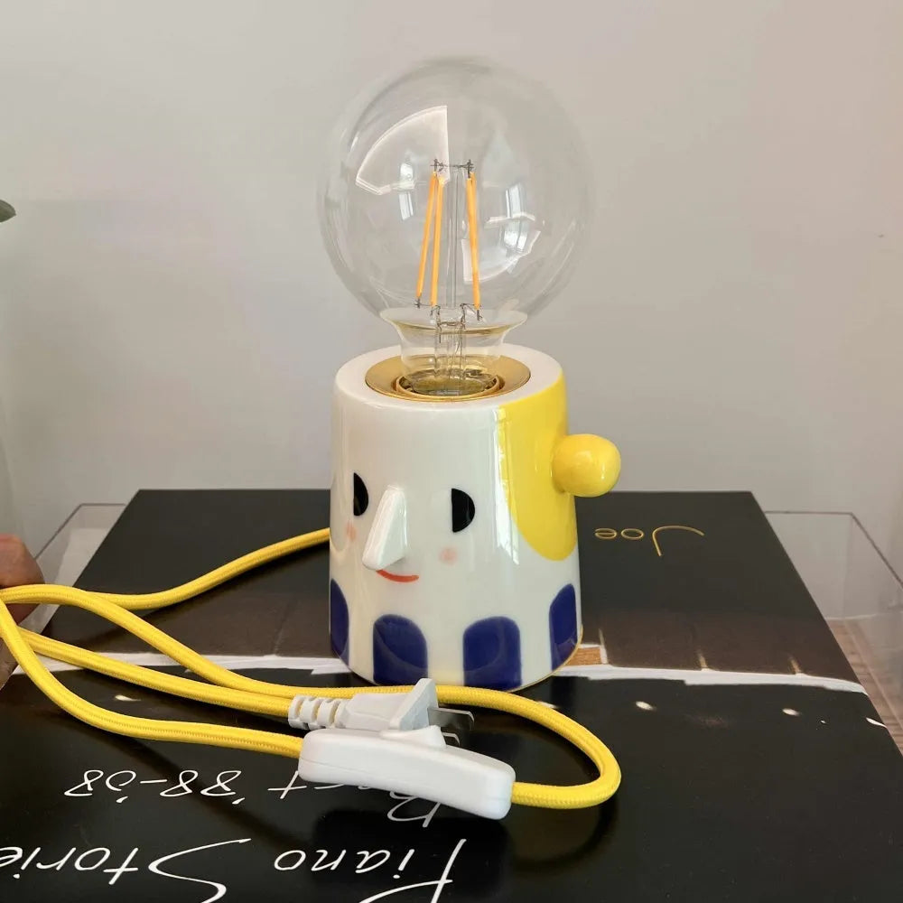 Handmade ceramic ball headlight bedside lamp on a table.