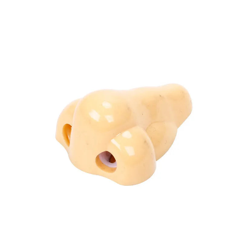 Flesh coloured geometry-shaped plastic manual pencil sharpener on a white background.