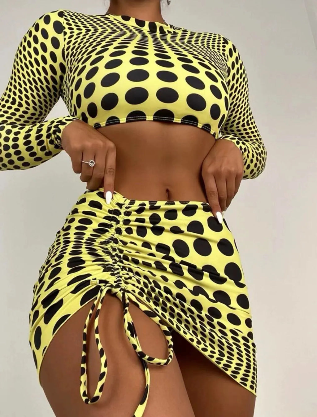 Women's green polka dot three-piece swimsuit set with halterneck bikini top and matching skirt
