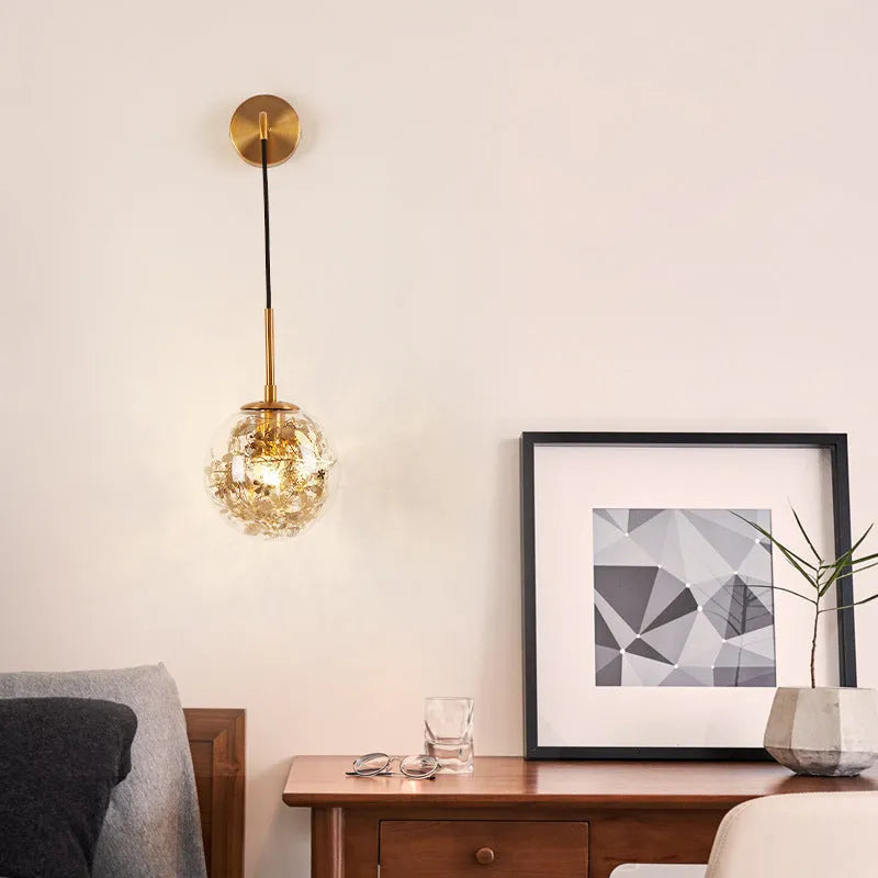 Modern glass wall lamp with metallic finish mounted beside bed for bedside lighting