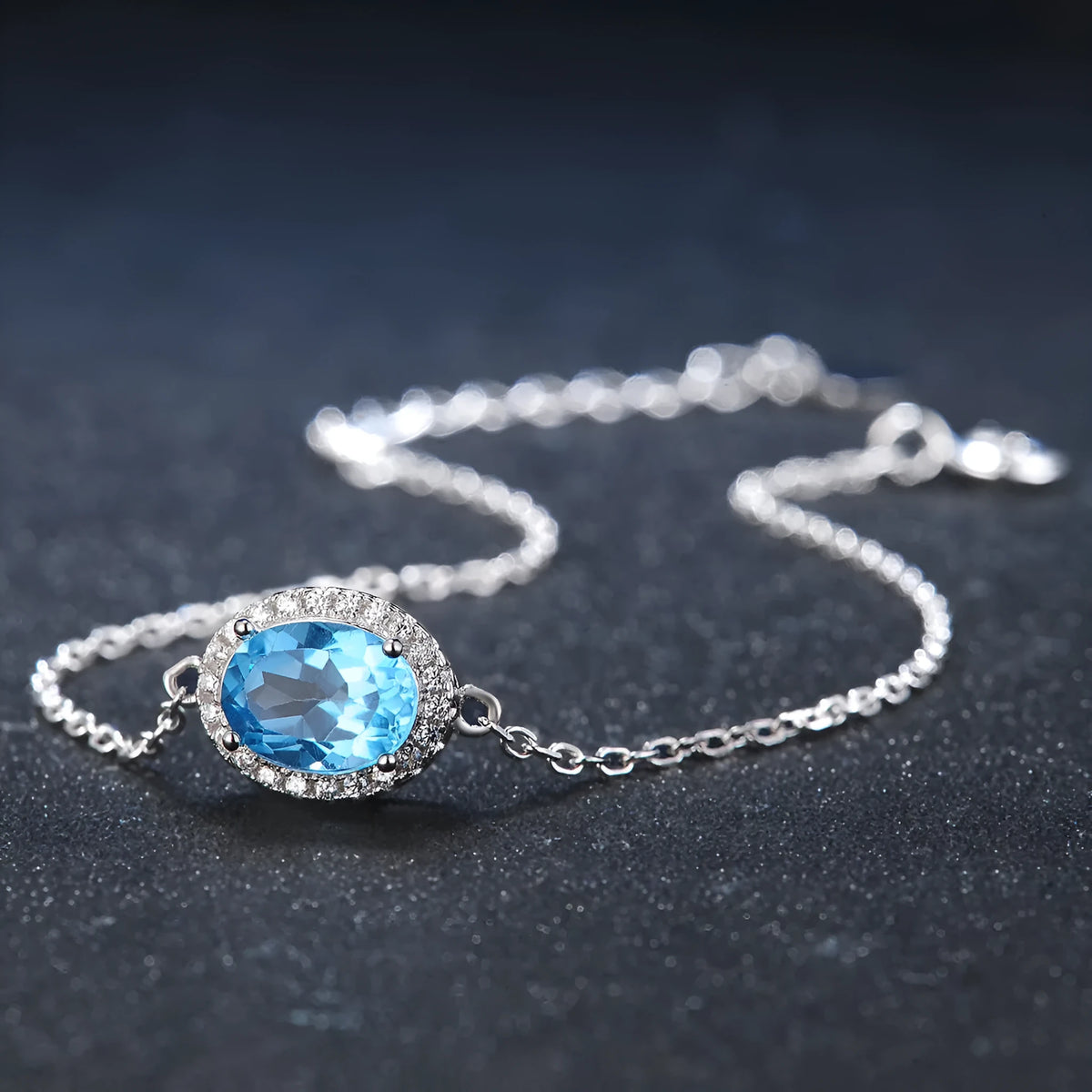 925 sterling silver geometric jewellery set with blue topaz gemstones, showing earrings, ring, pendant, and necklace.