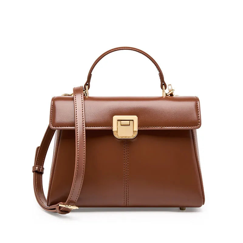 Women's black leather shoulder bag with vachette clasp showing internal zippered pocket