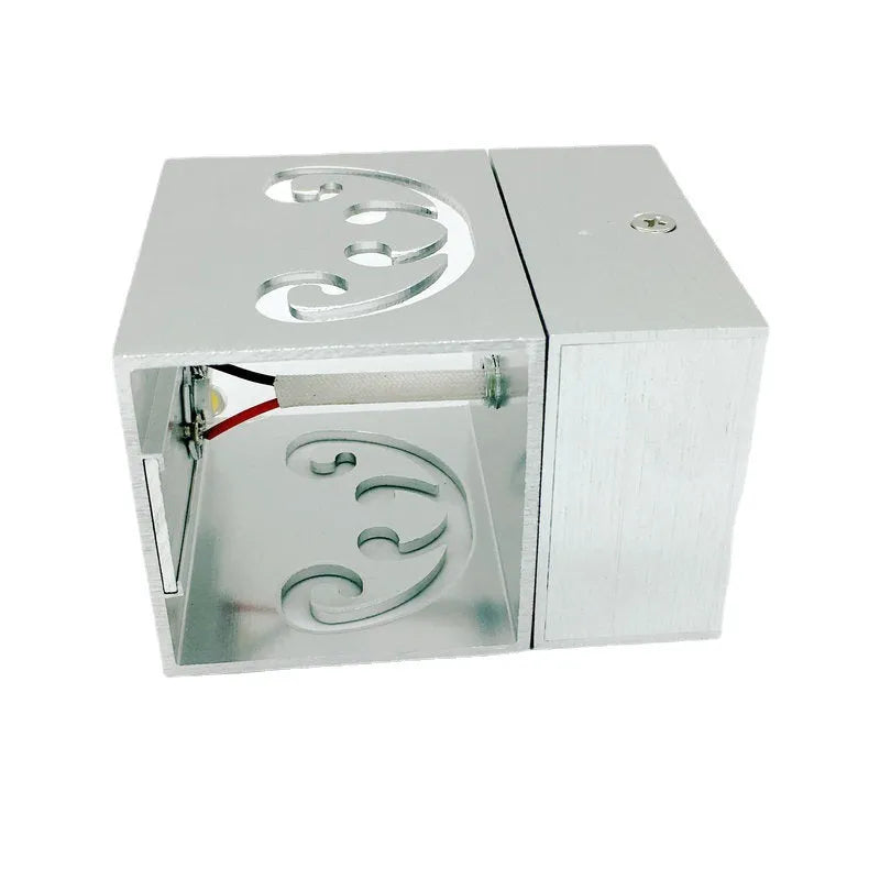 Modern aluminium butterfly-shaped LED wall lamp with remote control on a plain background.