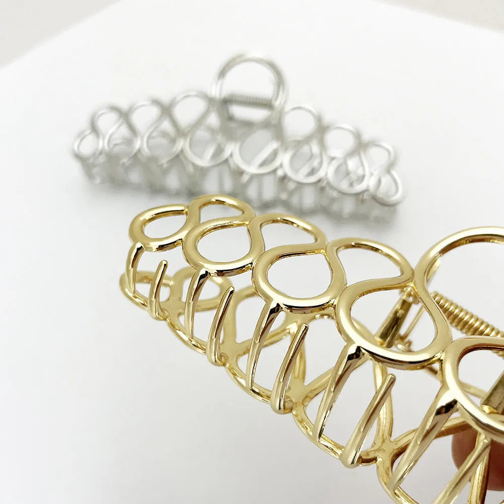 Large minimalist updo hair clip with tassel detail in gold or silver electroplated finish.