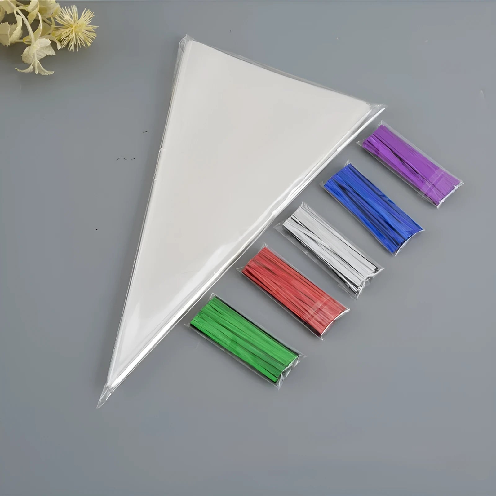 Transparent triangle-shaped plastic packaging bag with a twisted wire tie closure.