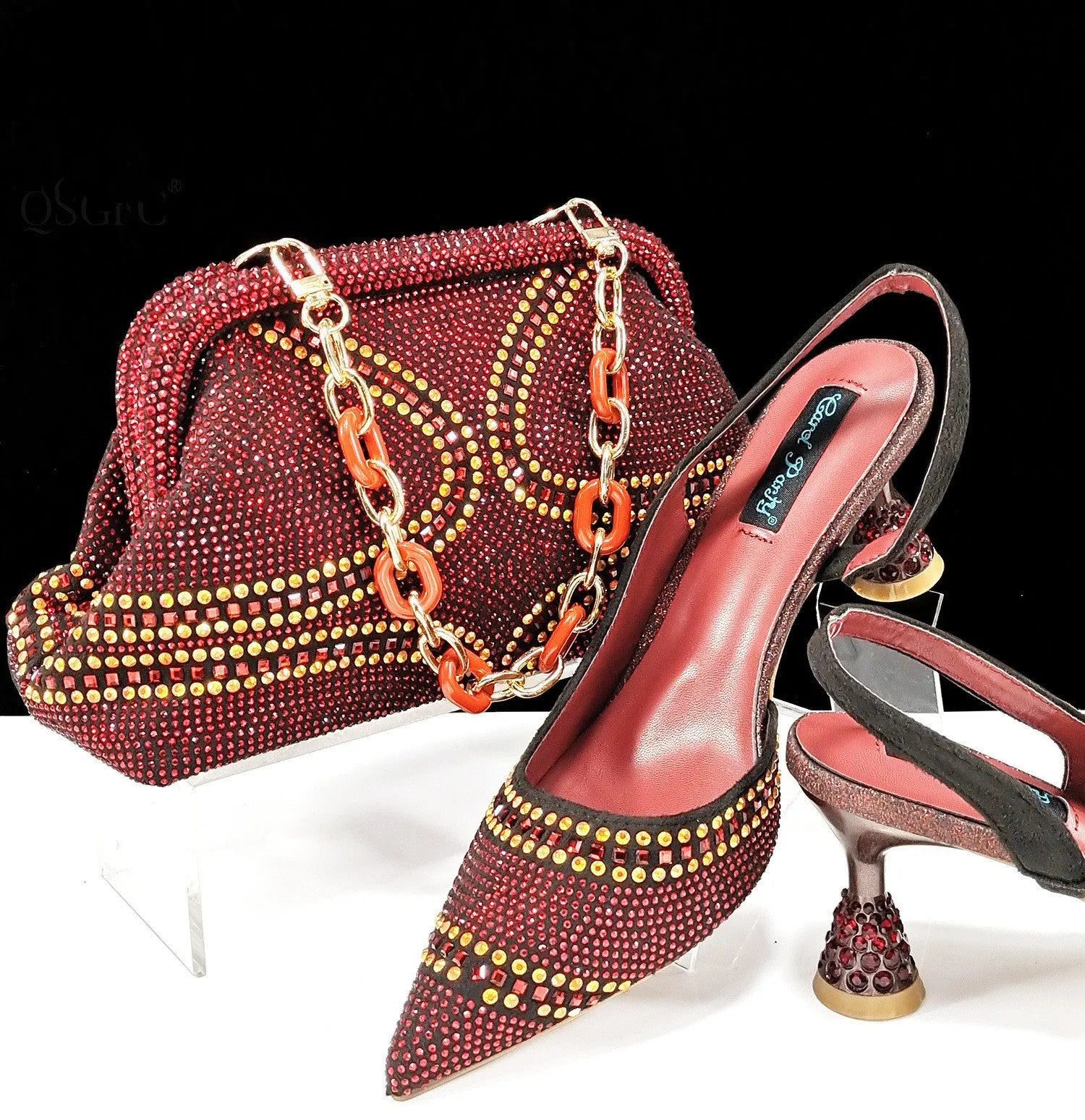 Women's pointed toe high heel shoes with stiletto heel and rhinestones, shown with a matching small bag.