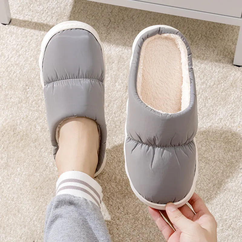 Blue down cotton slippers with artificial leather upper, thick rubber sole, and plush lining shown on a wooden floor.