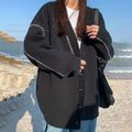 A loose-fitting black women's knitted cardigan top coat with long sleeves.
