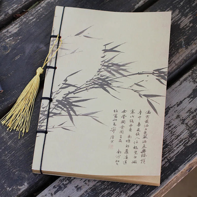 A5 antique wire-bound notebook with glossy embossed cover featuring a retro painting design, shown open.