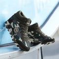 Green camouflage pattern women's canvas trainers with a raised rubber sole.
