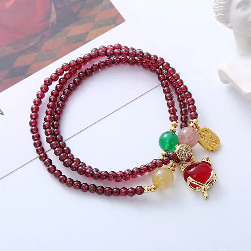 Purplish red garnet crystal fox bracelet on an adjustable rope for women.
