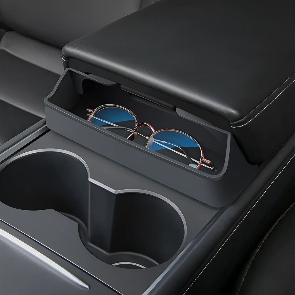 Black silicone glasses storage case accessory installed in a Tesla Model 3 or Y centre console armrest.