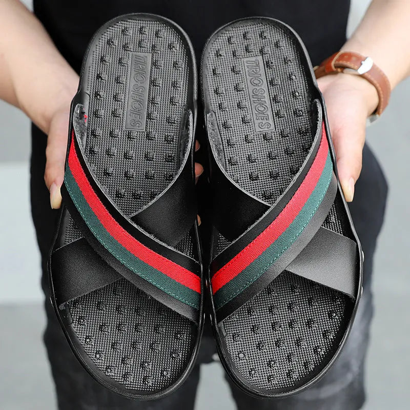 Men's black cowhide leather beach sandals with a non-slip PU sole on a sandy background.