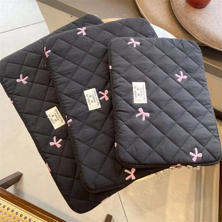 Nylon laptop storage bag with a rhombus-shaped embroidered bow on the front.