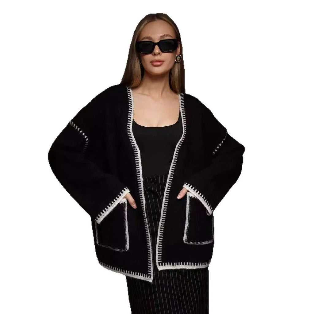 Loose mid-length knitted cardigan sweater coat with a lace-up front, shown in a neutral colour.