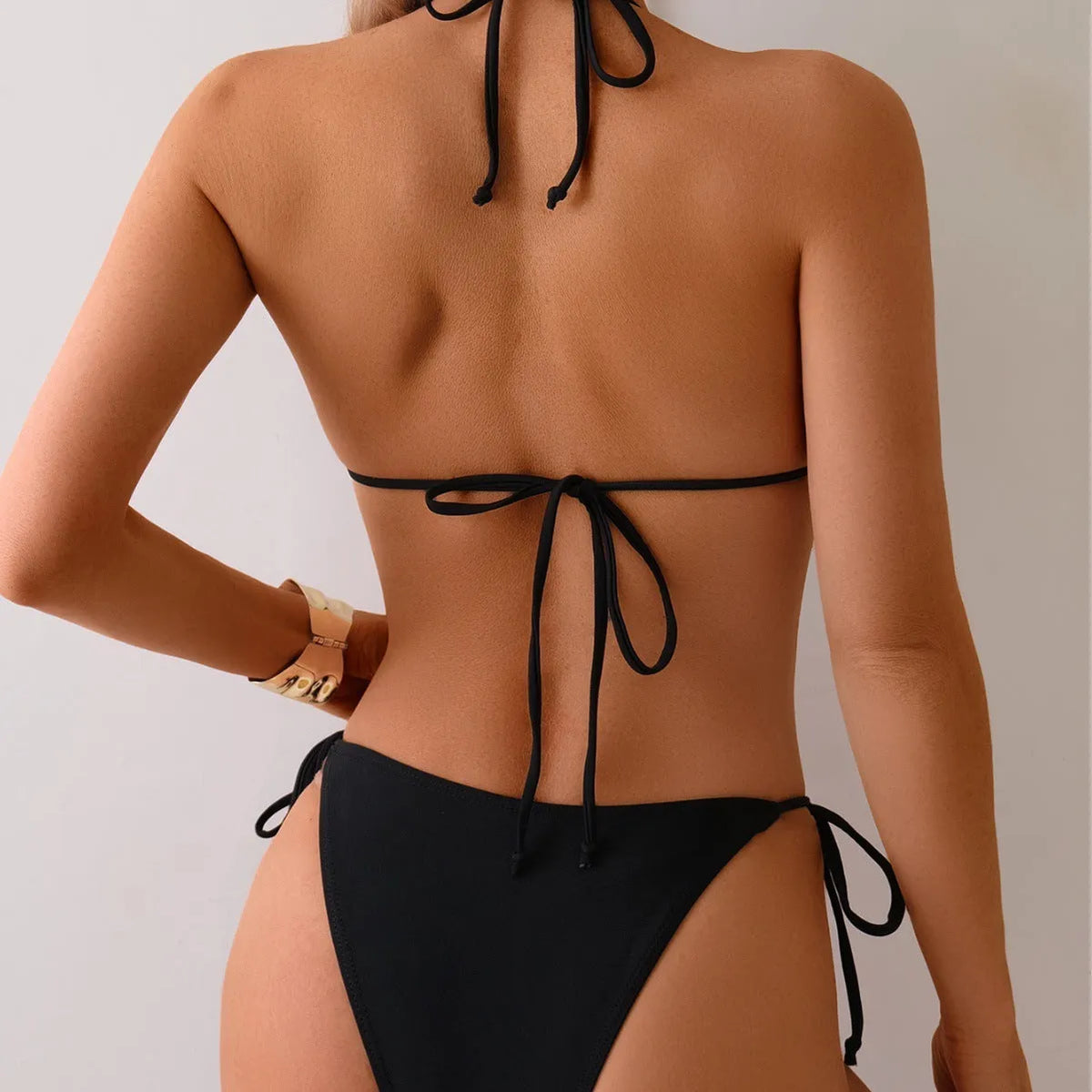 Black women's bikini swimsuit with metal bead detail on a split style design